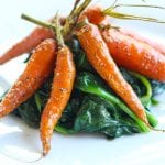 simple smoked carrots on a plate of spinach